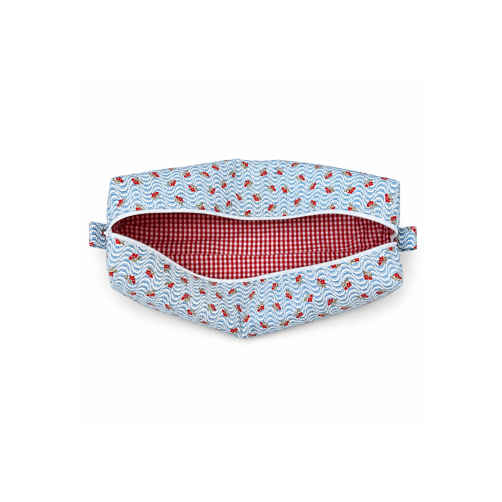 A fabric pouch with a light blue and white wavy pattern and small red details, featuring a red and white gingham checkered lining, shown open on a white background. Handmade Style Bag hair tool organizer.