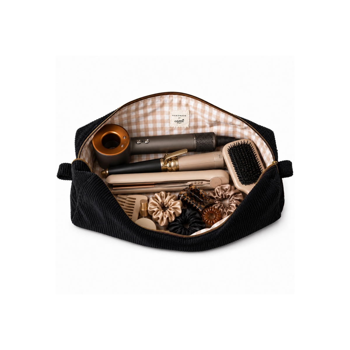 An open black corduroy cosmetic pouch with a beige and white gingham lining, filled with various hair and grooming accessories including brushes, combs, and a hair stick, on a white background.Corduroy Classic hair tool organizer size and fit