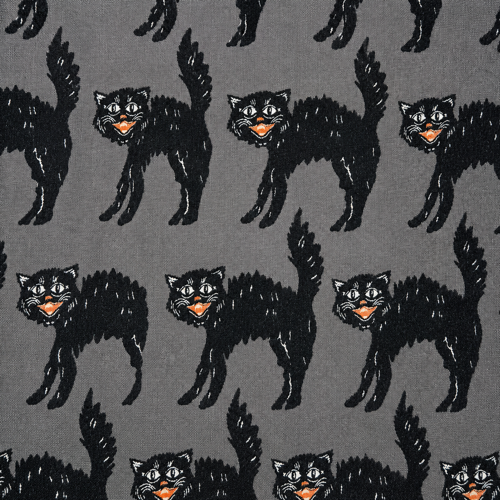 A repeating pattern of black cats with orange and white details on a dark gray background.